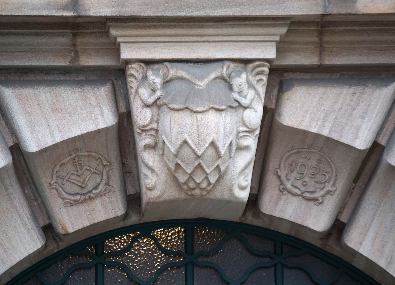Fassadenschmuck an der ehemaligen AOK / Grillenberger Straße Schlussstein mit einem Zapfen und zwei Eichhörnchen