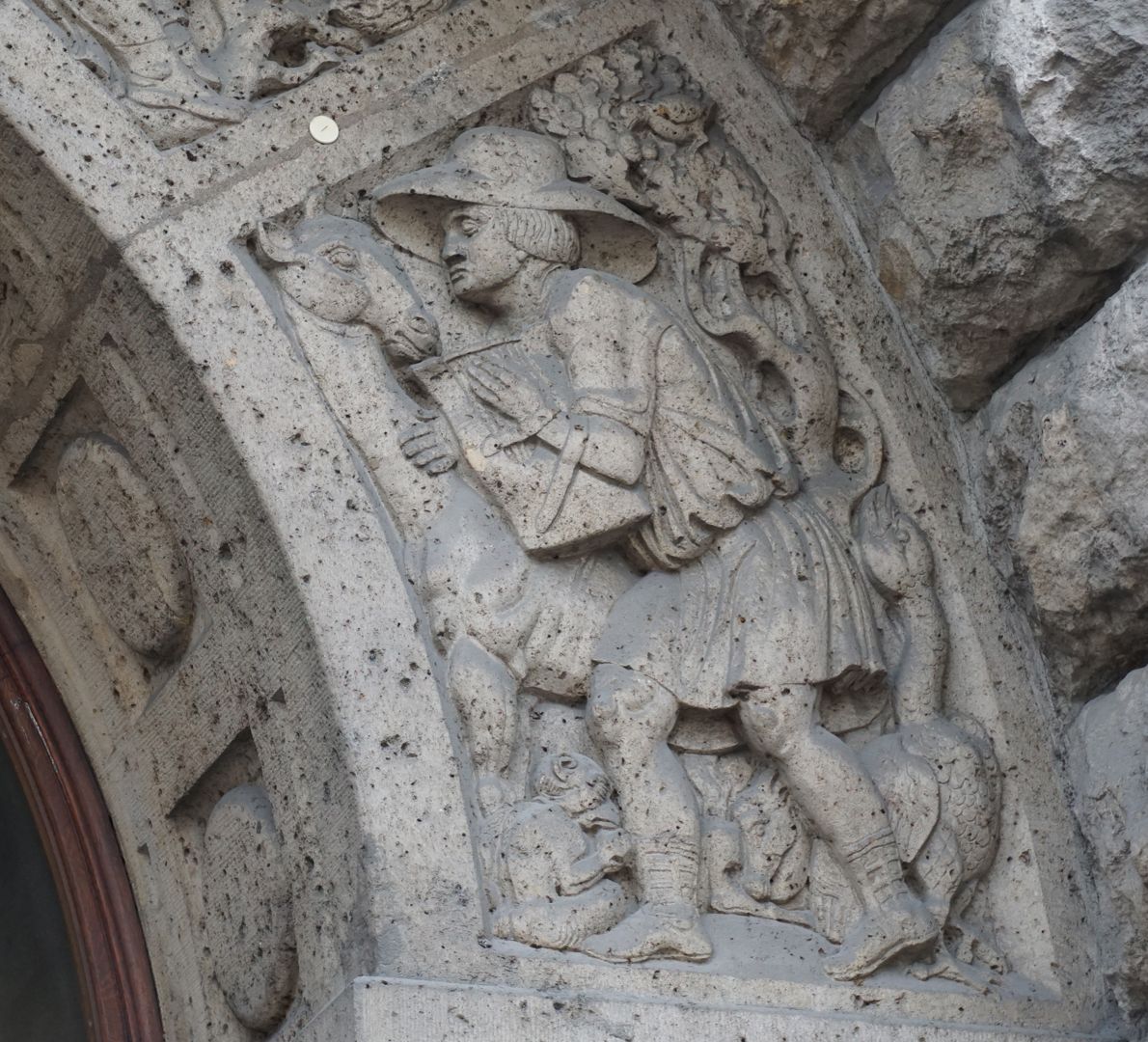 facade decoration at Melanchthon-Gymnasium "Music", a male figure carrying a lyre and surrounded by animals, which turn towards him