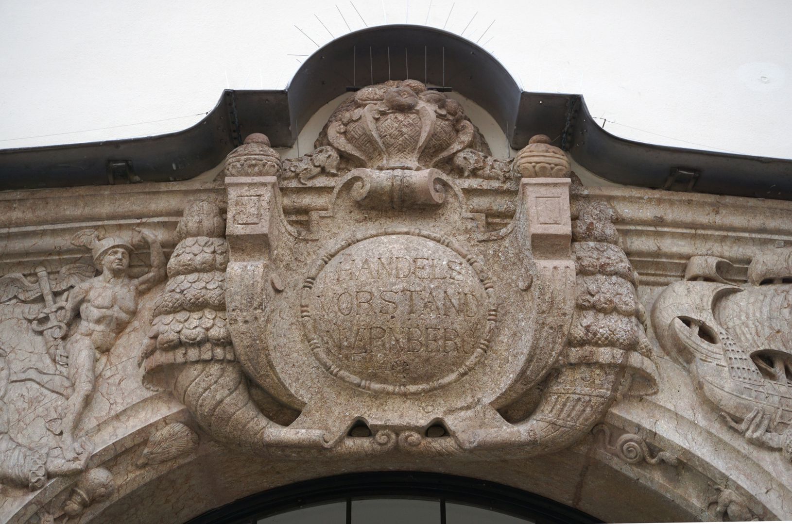 Portal cartouche above the archway, framed by cornucopias