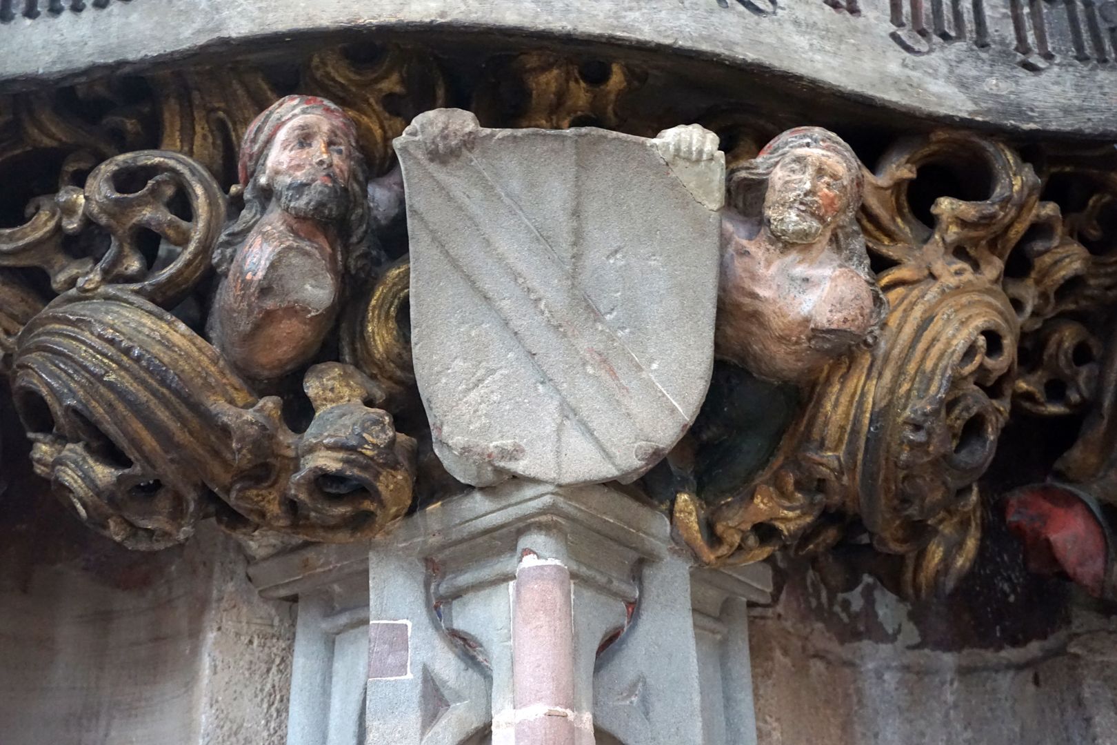 Epitaph of Hans Rebeck Wappenträger mit Wappen, bei beiden ist der vordere Arm abgegangen, der "Abdruck" der Hände ist am unteren Wappenrand noch zu sehen