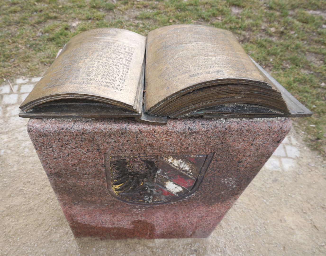 Noris Fountain Unbinding bronze book with donor's dedication on a stone desk with the city's coat of arms