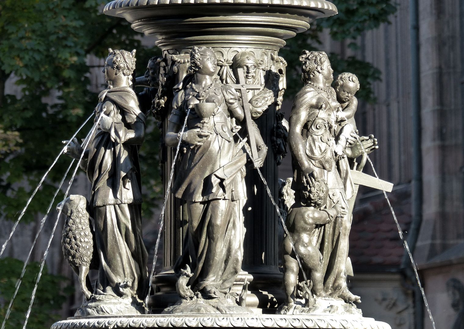 Tugendbrunnen Von links nach rechts: Die Tugend der Geduld mit einem Lamm / Die Tugend des Glaubens mit Kelch und Kreuz / Die Tugend der Liebe mit zwei Kindern