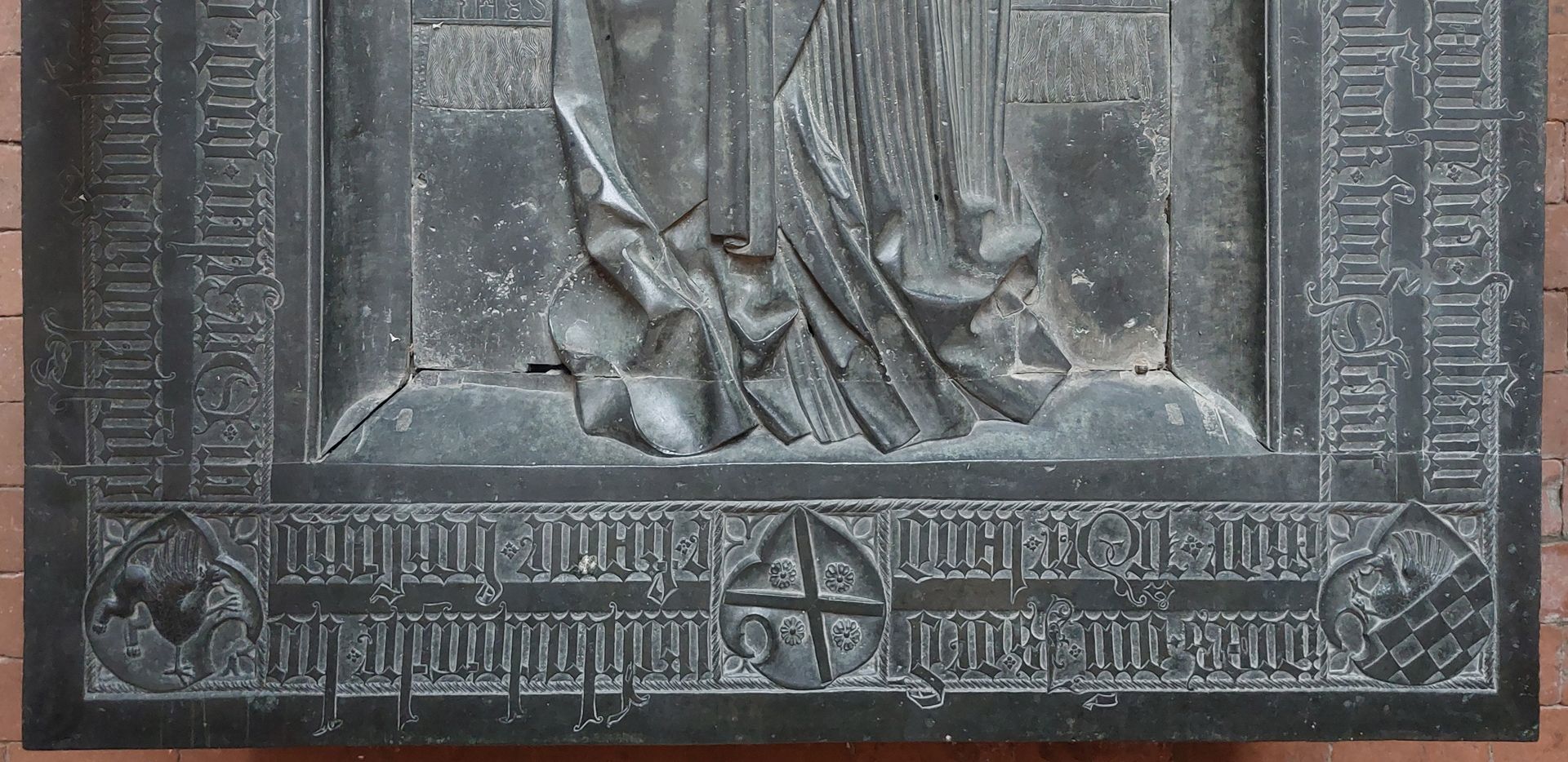 Grabplatte der Herzogin Sophia von Mecklenburg, Prinzessin von Pommern umlaufende Inschrift der unteren Platte, links das Wappen von Barth mit dem Greif, mittig das Andreaskreuz des Wappens von Gützkow und rechts das Wappen von Wolgast (geteilt, oben wachsender Greif, unten gescheckt)