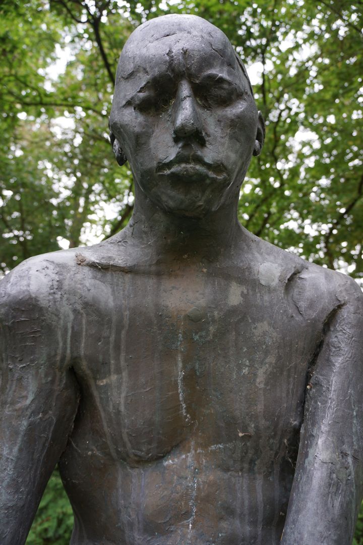 Sitzende Bronzefigur Oberkörper, Untersicht von vorne